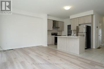Pickering townhouse for rent - A kitchen with a white counter top and wooden floors.