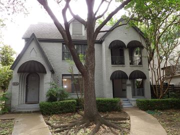 Dallas apartment for rent - A grey house with a black door and a tree in front.