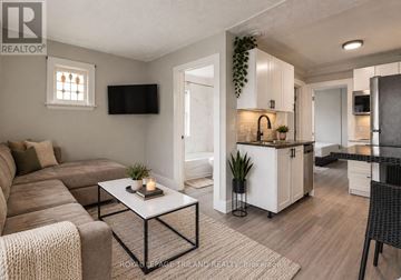 London South (South F) multi-family for rent - A modern living room with a brown sofa and a white coffee table.