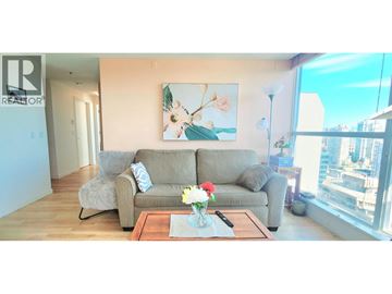 Vancouver apartment for rent - A living room with a grey couch, a coffee table, and a painting on the wall.