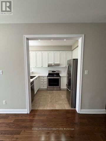 Brampton (Sandringham-Wellington) townhouse for rent - A kitchen with white cabinets and stainless steel appliances.