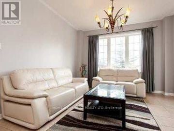 Mississauga (East Credit) apartment for rent - A living room with two white leather sofas and a glass coffee table.
