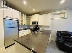 Vancouver apartment for rent - A kitchen with a refrigerator, microwave, and oven.