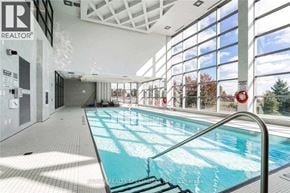 Mississauga (Central Erin Mills) condo for rent - A large indoor swimming pool with a glass wall on one side.