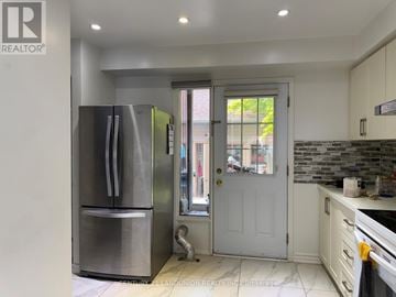 Toronto (Rouge) townhouse for rent - A modern kitchen with a stainless steel refrigerator and white cabinets.