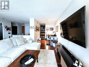 Toronto (Willowdale East) condo for rent - A modern living room with a white sofa and a flat screen TV.