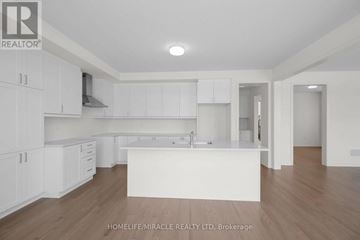 Adjala-Tosorontio (Colgan) apartment for rent - A spacious kitchen with white cabinets and a central island.