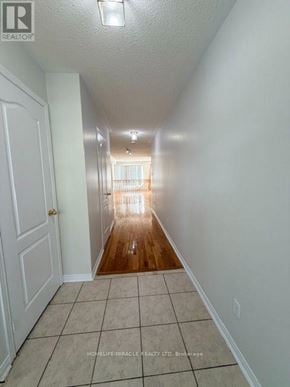 Mississauga (Meadowvale Village) townhouse for rent - A long hallway with a door on the left and a window at the end.