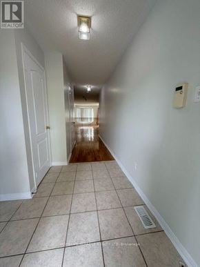 Mississauga (Meadowvale Village) townhouse for rent - A long hallway with tiled floors and white walls.