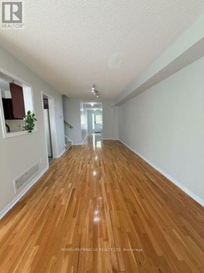 Mississauga (Meadowvale Village) townhouse for rent - A long hallway with wooden floors and white walls.