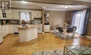 Kitchener apartment for rent - A well-lit kitchen with wooden floors and a dining area with a table and chairs.
