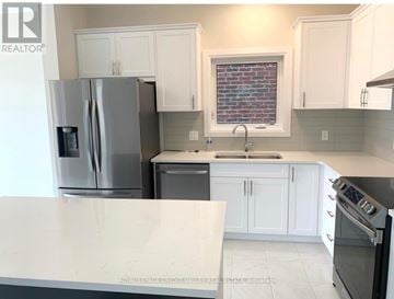 Waterloo apartment for rent - A kitchen with white cabinets and a stainless steel refrigerator.