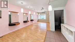 Toronto (Weston-Pellam Park) apartment for rent - A spacious room with pink walls and wooden flooring, featuring mirrors and a bench.