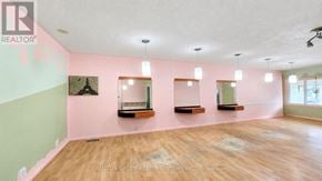 Toronto (Weston-Pellam Park) apartment for rent - A room with pink walls and wooden floors, with a realtor logo in the corner.