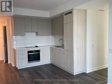 Vaughan (Vaughan Corporate Centre) condo for rent - A kitchen with white cabinets and a black oven.
