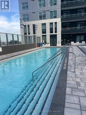 Vaughan (Vaughan Corporate Centre) condo for rent - A swimming pool on a rooftop with a building in the background.