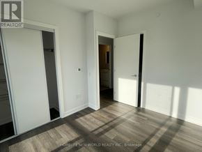 Vaughan (Vaughan Corporate Centre) condo for rent - A room with white walls and wooden flooring, with a doorway leading to another room.