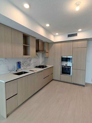 Surrey apartment for rent - A modern kitchen with wooden cabinets and stainless steel appliances.