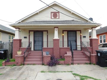 New Orleans apartment for rent - A house with a red brick pillar and a black door.