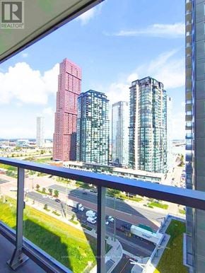 Vaughan (Vaughan Corporate Centre) condo for rent - A cityscape with a red building in the middle and a glass building on the right.