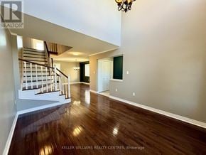 Barrie (400 West) apartment for rent - A spacious room with wooden floors and a staircase leading to the upper level.