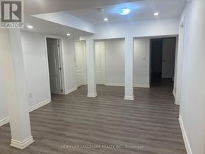 Richmond Hill (Westbrook) apartment for rent - A spacious room with wooden flooring and white walls.
