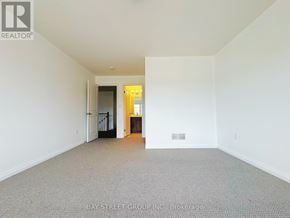 Niagara Falls (Brown) townhouse for rent - A large empty room with a doorway leading to another room.