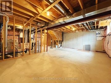 Niagara Falls (Brown) townhouse for rent - A spacious unfinished room with wooden beams and insulation on the walls.