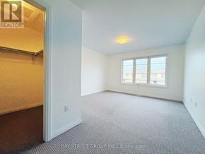 Niagara Falls (Brown) townhouse for rent - A room with a carpeted floor and a window with a view of the city.