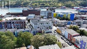 St. John's house for rent - A cityscape with buildings in various colors and a body of water in the background.