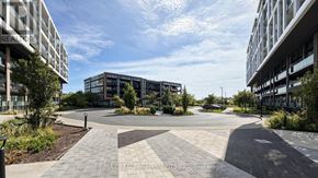 Toronto (Downsview-Roding-Cfb) condo for rent - A modern building complex with a circular driveway in the foreground.