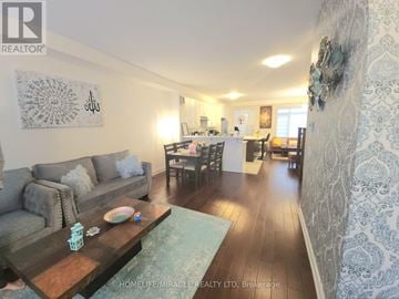 Brampton (Northwest Brampton) townhouse for rent - A living room with a grey couch and a wooden coffee table.