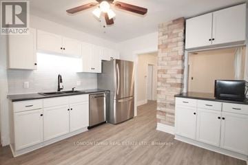 London East (East G) apartment for rent - A kitchen with white cabinets and a brick wall.