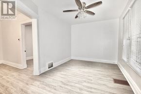London East (East G) apartment for rent - A room with a ceiling fan and light, hardwood floors, and white walls.