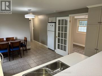 Collingwood apartment for rent - A kitchen with a table and chairs in the foreground and a refrigerator in the background.