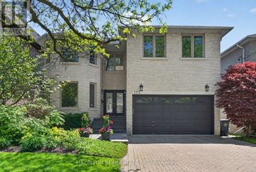 Toronto (Willowdale East) apartment for rent - A two-story house with a garage and a front yard with a tree and flowers.