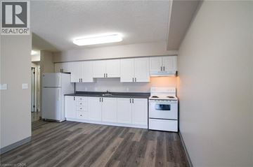 Waterloo apartment for rent - A kitchen with white cabinets and a stove top oven.