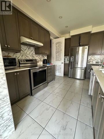 Brantford apartment for rent - A kitchen with brown cabinets and a marble backsplash.
