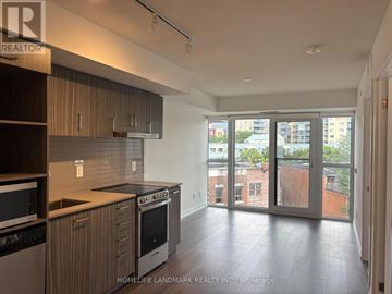 Toronto (Moss Park) condo for rent - A kitchen with wooden cabinets and a black dishwasher.