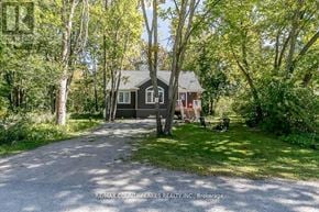 Ramara (Brechin) apartment for rent - A house is surrounded by trees and has a driveway leading to it.