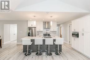 Ramara (Brechin) apartment for rent - A modern kitchen with white bar stools and a central island.