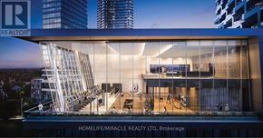 Mississauga (City Centre) condo for rent - A modern building with a glass facade and a sign that reads "REALTOR".