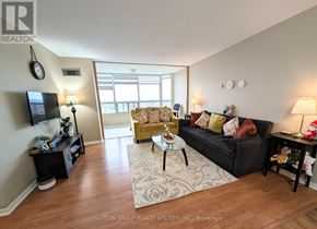 Mississauga (City Centre) condo for rent - A living room with a black couch, a coffee table, and a television.