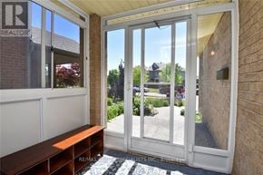 Hamilton (Kernighan) multi-family for rent - A white door with a glass window and a bench in front of it.
