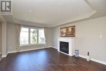 Hamilton (Kernighan) multi-family for rent - A living room with a fireplace and a painting on the wall.