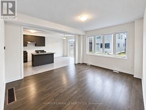 Welland (Dain City) apartment for rent - A spacious living room with a kitchen in the background.