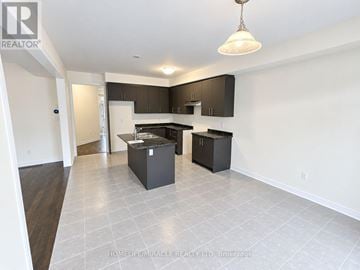 Welland (Dain City) apartment for rent - A spacious kitchen with black cabinets and white appliances.