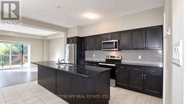 Kitchener townhouse for rent - A kitchen with black cabinets and a black countertop.