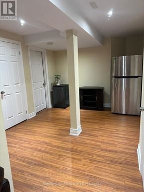 Whitby (Brooklin) apartment for rent - A room with a wooden floor and a stainless steel refrigerator.