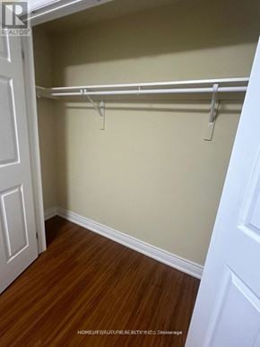 Whitby (Brooklin) apartment for rent - A white door is on the left of a room with a wooden floor and a wall with a coat rack.